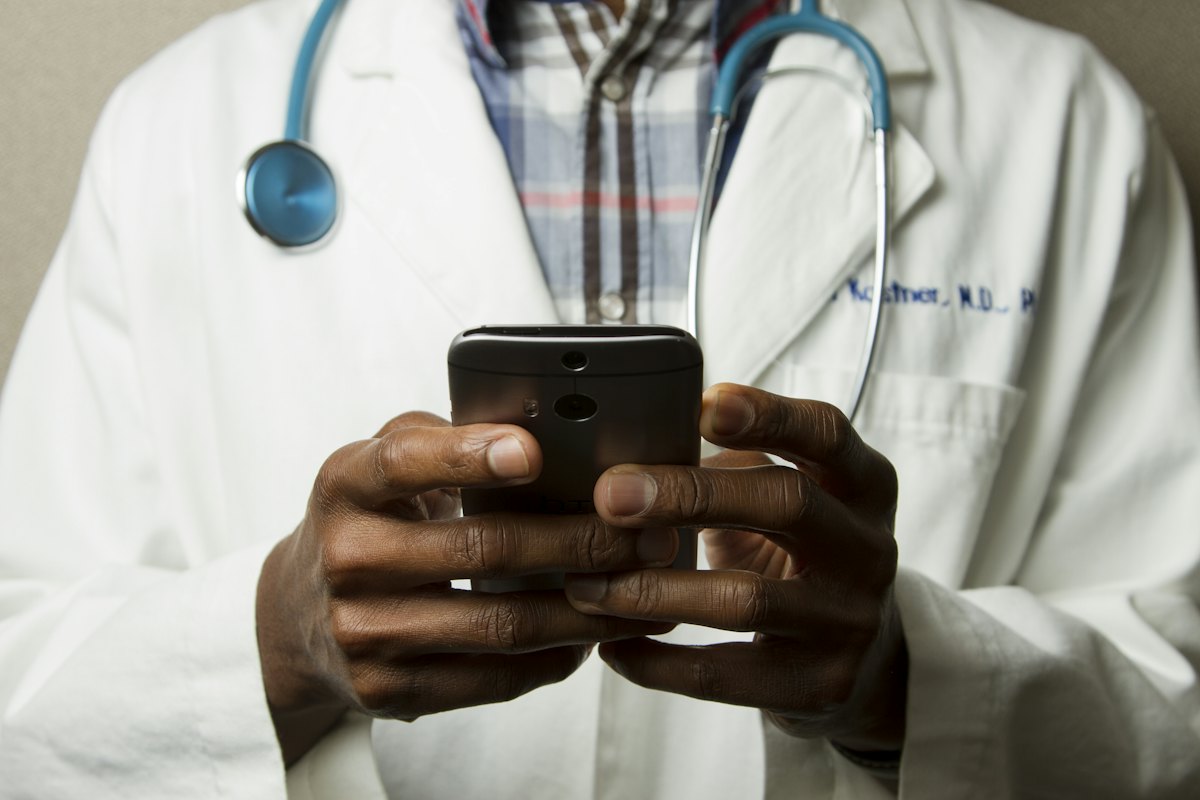 Dokter membuka aplikasi konsultasi di ponselnya